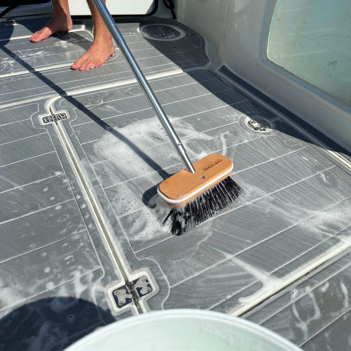 Hard bristle brush scrubbing deck